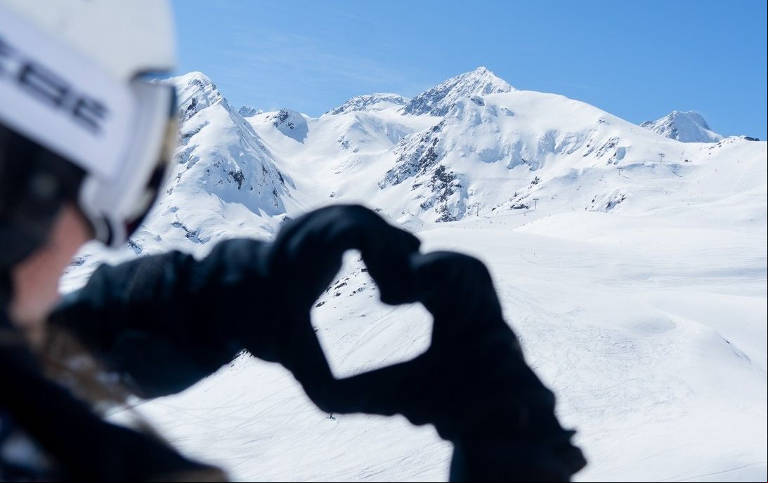 Un esquiador forma un corazón con sus manos en Peyragudes